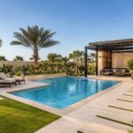 Modern Dubai villa featuring a swimming pool, landscaped garden, pergola, outdoor seating, lush greenery, and tiled walkways designed as one integrated outdoor living space.